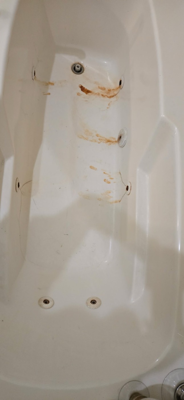 Jetted tub with rust stains before refinishing